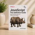 JavaScript: The Definitive Guide by David Flanagan – O'Reilly paperback standing upright in a lifestyle setting